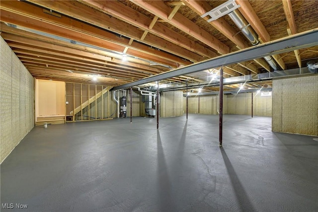 unfinished basement featuring gas water heater and visible vents