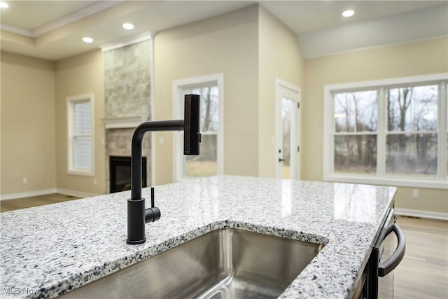 kitchen featuring wood finished floors, light stone counters, and recessed lighting