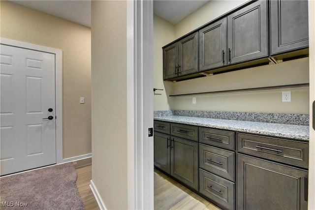 bar featuring baseboards and light wood finished floors