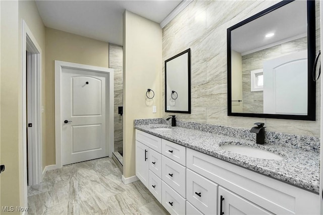 bathroom featuring double vanity, marble finish floor, tiled shower, and a sink