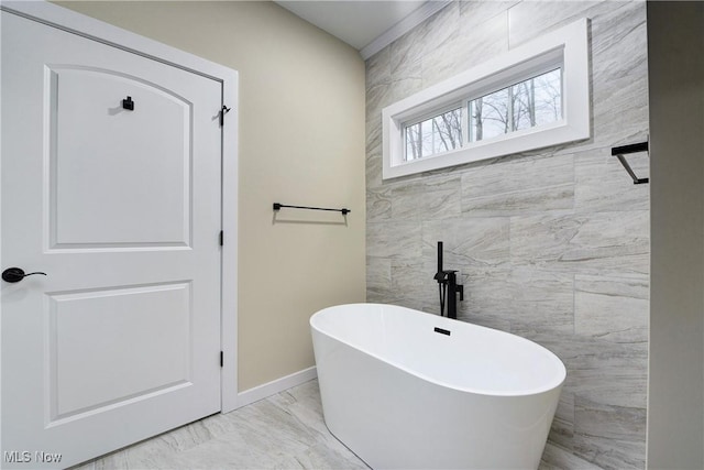 full bath with tile walls, baseboards, marble finish floor, and a freestanding bath