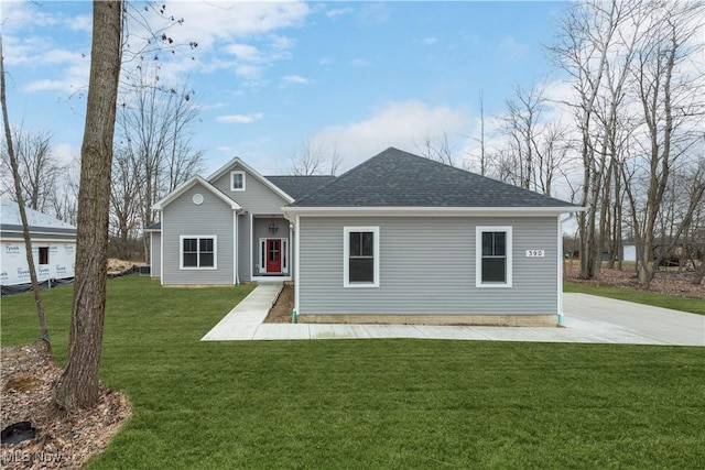 view of front of house with a shingled roof and a front yard