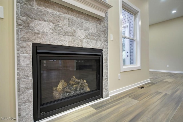 room details featuring recessed lighting, wood finished floors, baseboards, and a tile fireplace