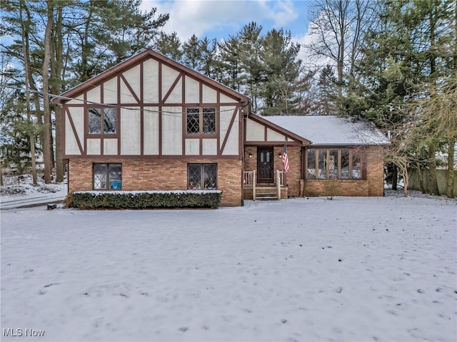 tudor home featuring brick siding and stucco siding