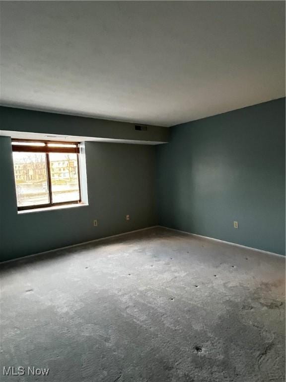 spare room featuring visible vents and carpet