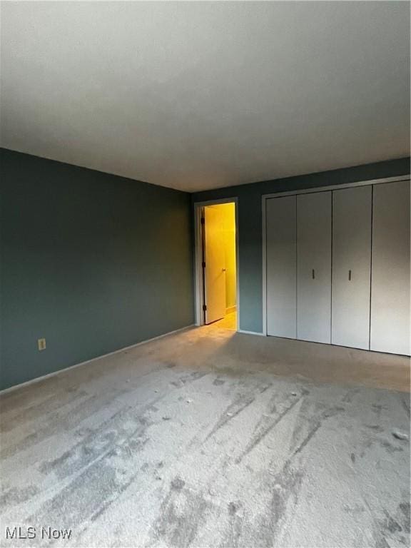 unfurnished bedroom with carpet and a closet