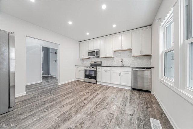 kitchen featuring plenty of natural light, backsplash, and appliances with stainless steel finishes