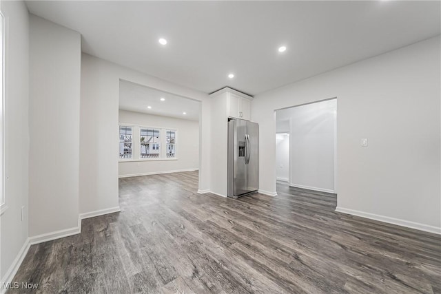 unfurnished living room featuring dark wood-type flooring, recessed lighting, and baseboards