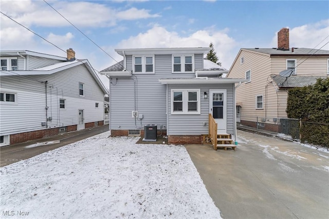 back of house featuring entry steps, central AC, and fence