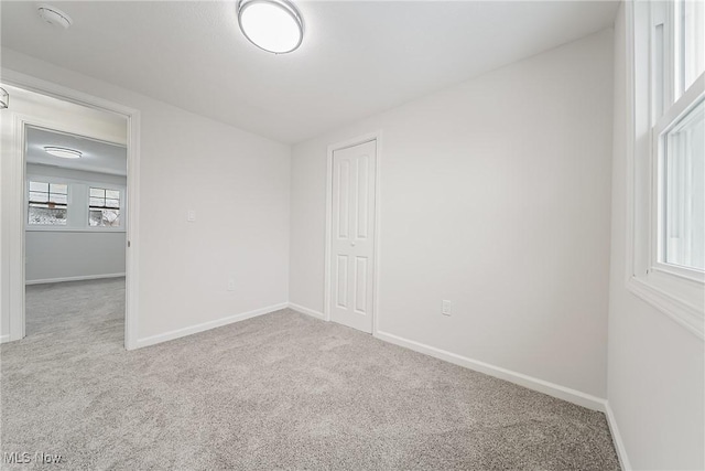 carpeted spare room with baseboards