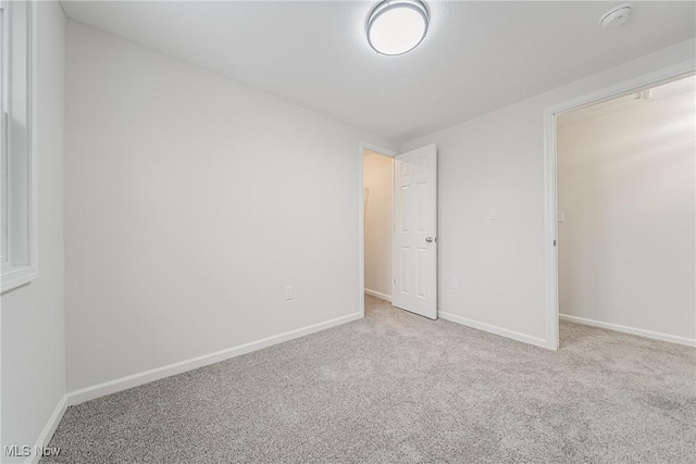 unfurnished bedroom with baseboards and carpet