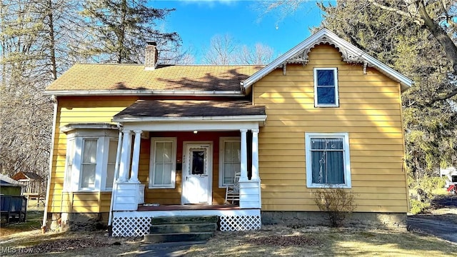 view of front of property with a porch and a chimney