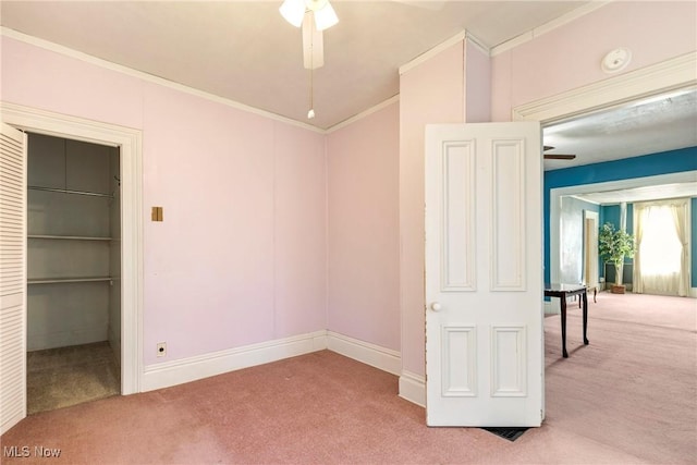 spare room featuring ceiling fan, carpet flooring, baseboards, and ornamental molding