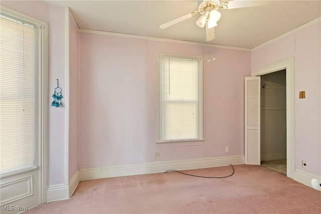 spare room featuring baseboards, carpet floors, a ceiling fan, and crown molding