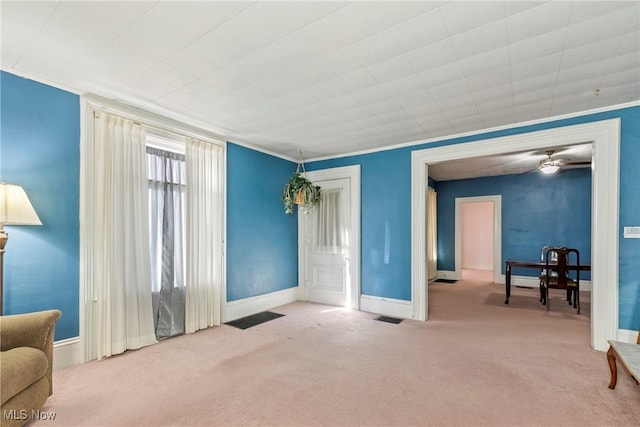 interior space with crown molding, baseboards, visible vents, and carpet floors