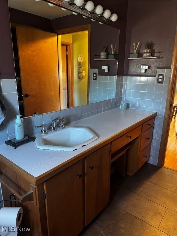 bathroom with tile patterned floors, vanity, and tile walls