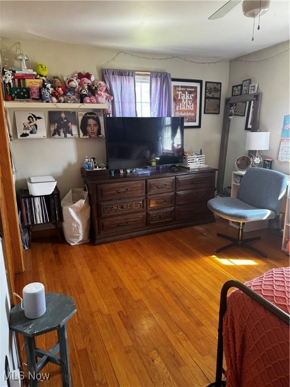 living area with light wood-style flooring and a ceiling fan