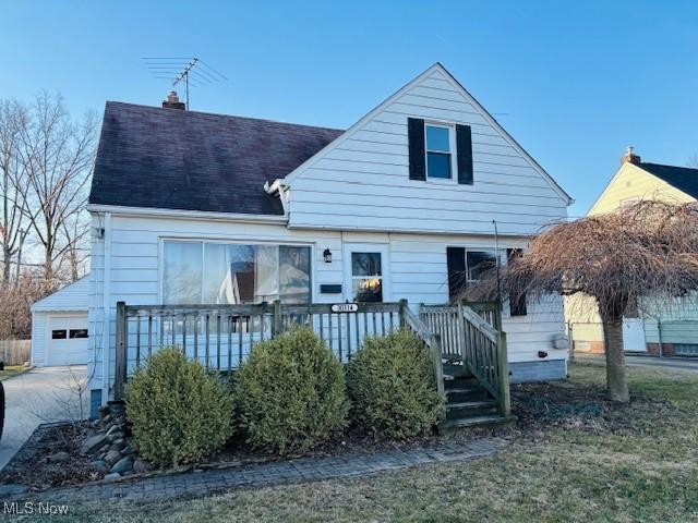 view of front of property featuring a garage, roof with shingles, and a chimney