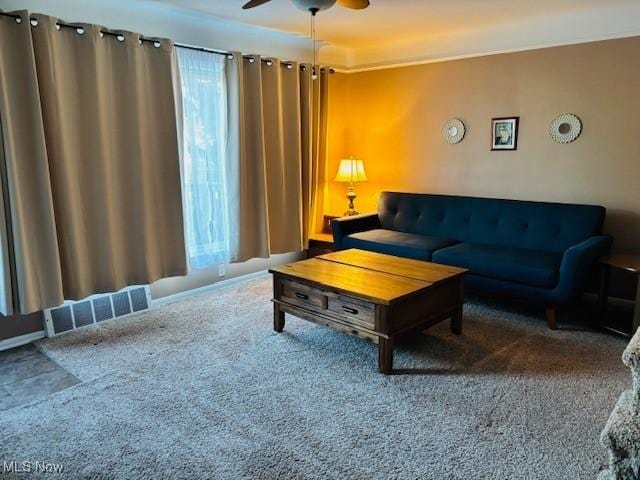 living room with carpet, visible vents, and ceiling fan