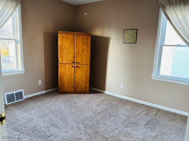 unfurnished bedroom featuring visible vents, carpet flooring, and baseboards