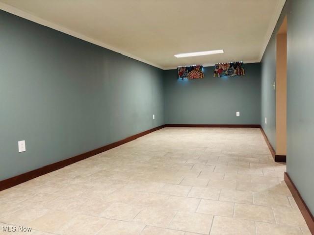 empty room with crown molding and baseboards