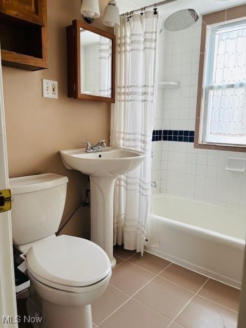 bathroom featuring tile patterned flooring, toilet, and shower / bath combo with shower curtain