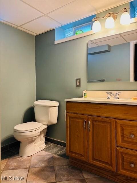 bathroom featuring vanity, toilet, a paneled ceiling, and baseboards