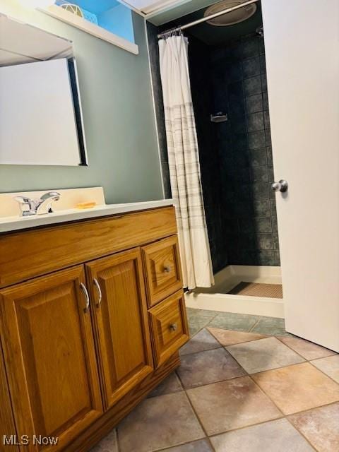 bathroom featuring tile patterned flooring, a stall shower, and vanity