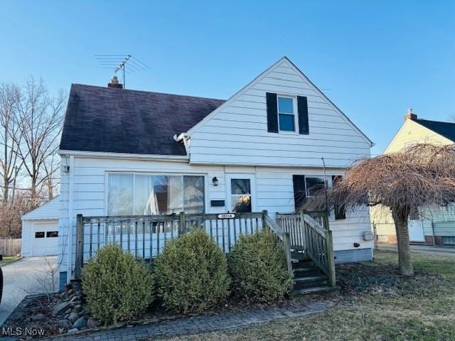 view of front of home with a garage, roof with shingles, and a chimney