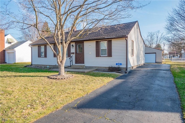 view of front of home featuring an outbuilding, entry steps, a detached garage, and a front lawn