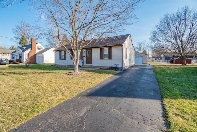 view of front facade with a garage, an outdoor structure, a front lawn, and fence