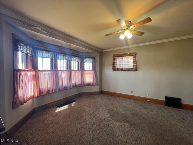 spare room with crown molding, carpet flooring, and baseboards