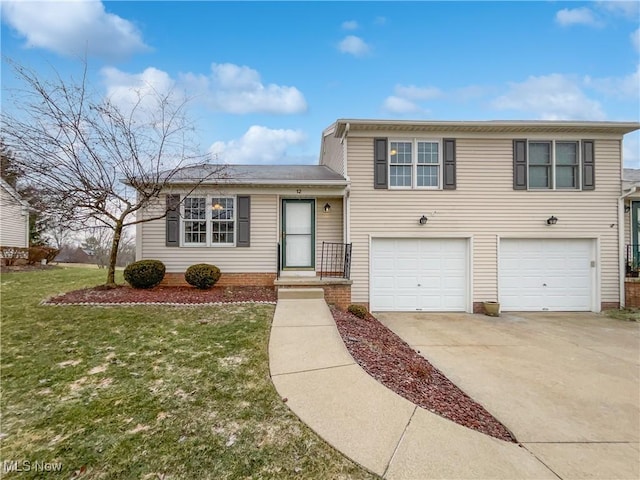 tri-level home with concrete driveway, a garage, and a front lawn