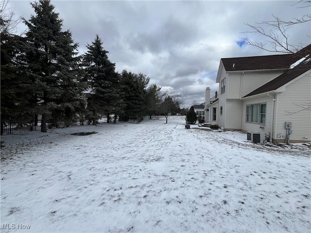 yard covered in snow featuring central air condition unit