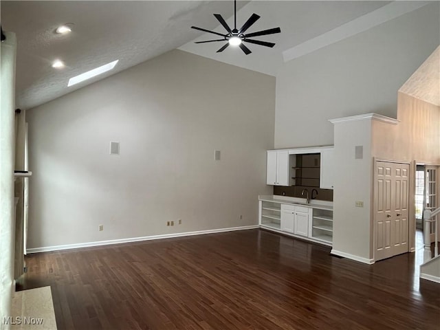 unfurnished living room featuring a sink, dark wood-type flooring, high vaulted ceiling, and a ceiling fan