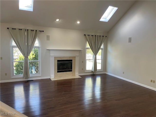 unfurnished living room featuring dark wood-style floors, visible vents, a high end fireplace, and baseboards