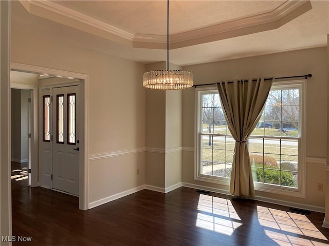 unfurnished dining area featuring a wealth of natural light, visible vents, a raised ceiling, and dark wood-style flooring