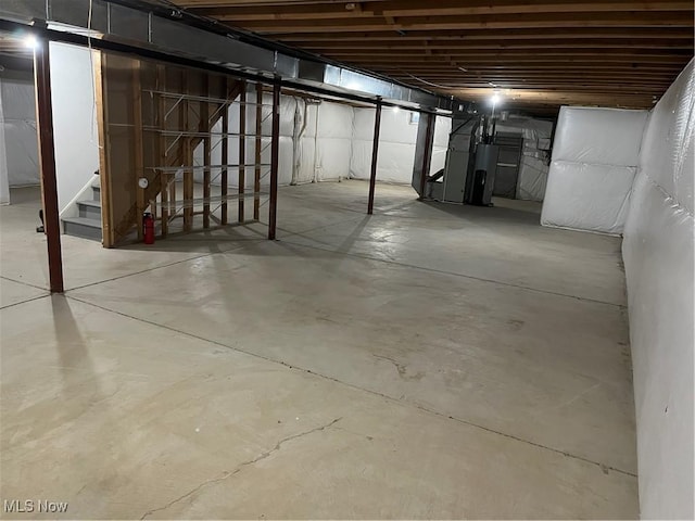 unfinished basement with stairs and water heater