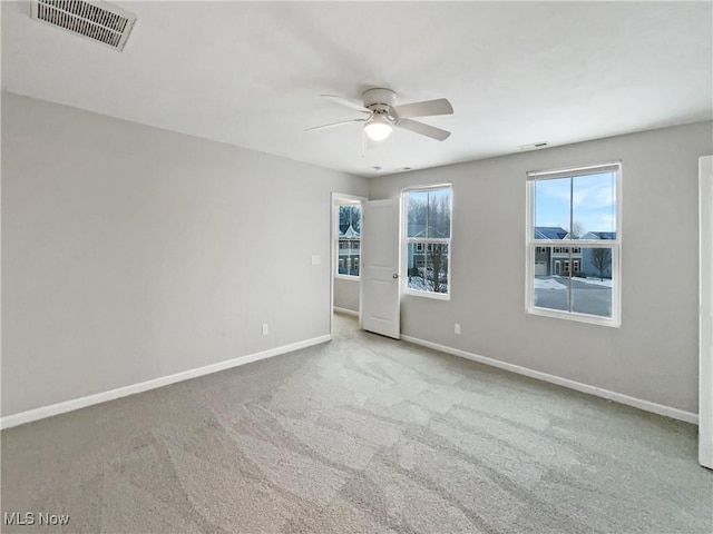 spare room featuring visible vents, baseboards, carpet, and a ceiling fan