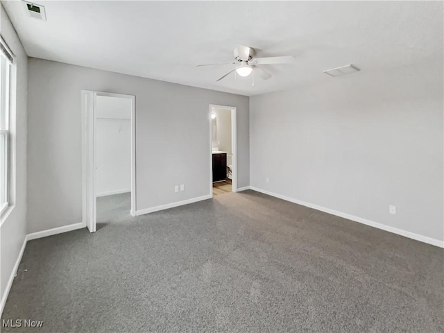 unfurnished bedroom featuring baseboards, carpet floors, and ensuite bathroom