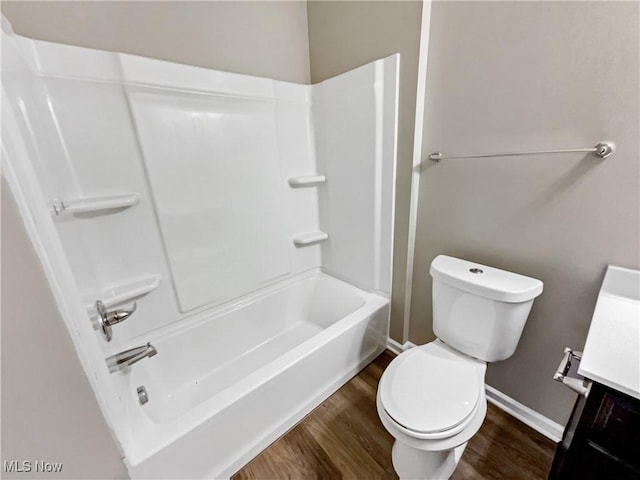 bathroom with toilet, vanity, and wood finished floors