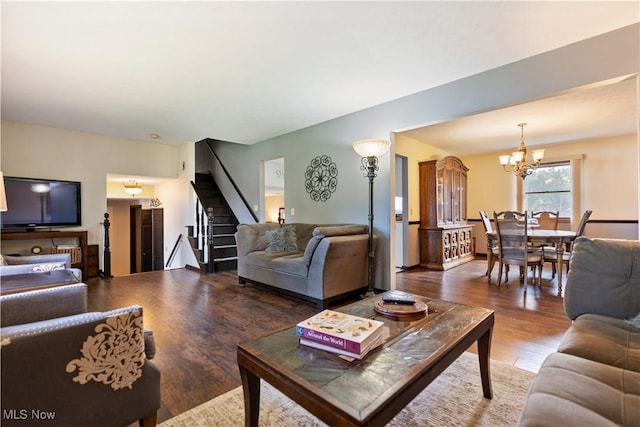 living area with stairs, wood finished floors, and a chandelier