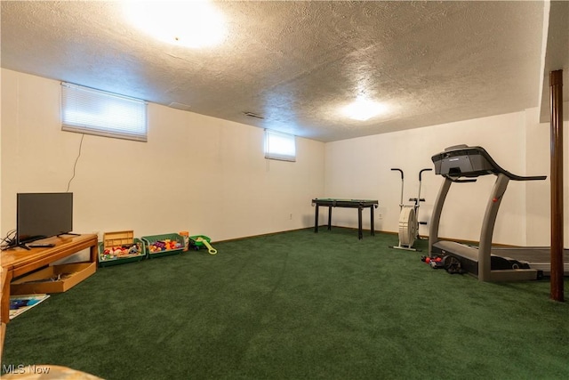 exercise area with carpet and a textured ceiling