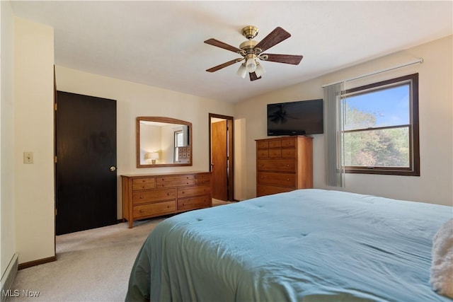 bedroom with lofted ceiling, light colored carpet, baseboards, and ceiling fan