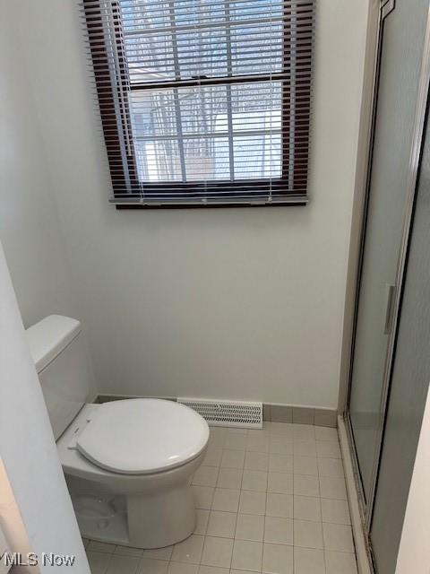 full bathroom with tile patterned floors, visible vents, a shower stall, and toilet