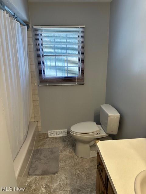 full bathroom featuring visible vents, shower / bath combo with shower curtain, toilet, and vanity