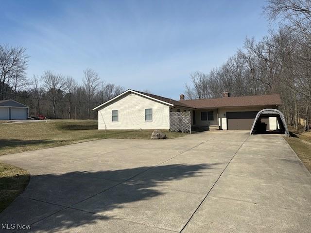 view of front of house featuring a chimney, concrete driveway, and a garage