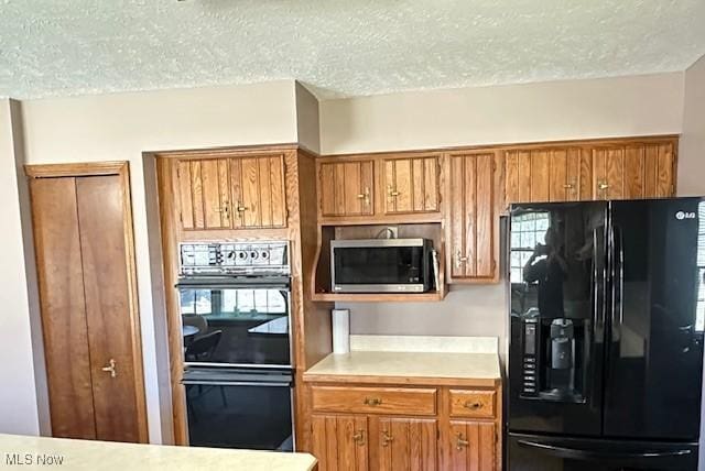 2364 W Royalton Rd, Broadview Heights, OH 44147 - kitchen with black appliances, brown cabinets, light countertops, and a textured ceiling