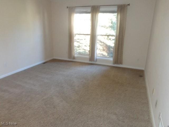 carpeted spare room with baseboards