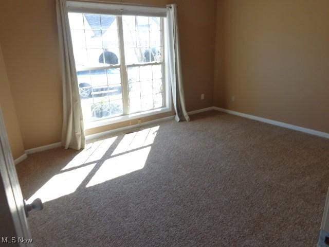 carpeted empty room with baseboards